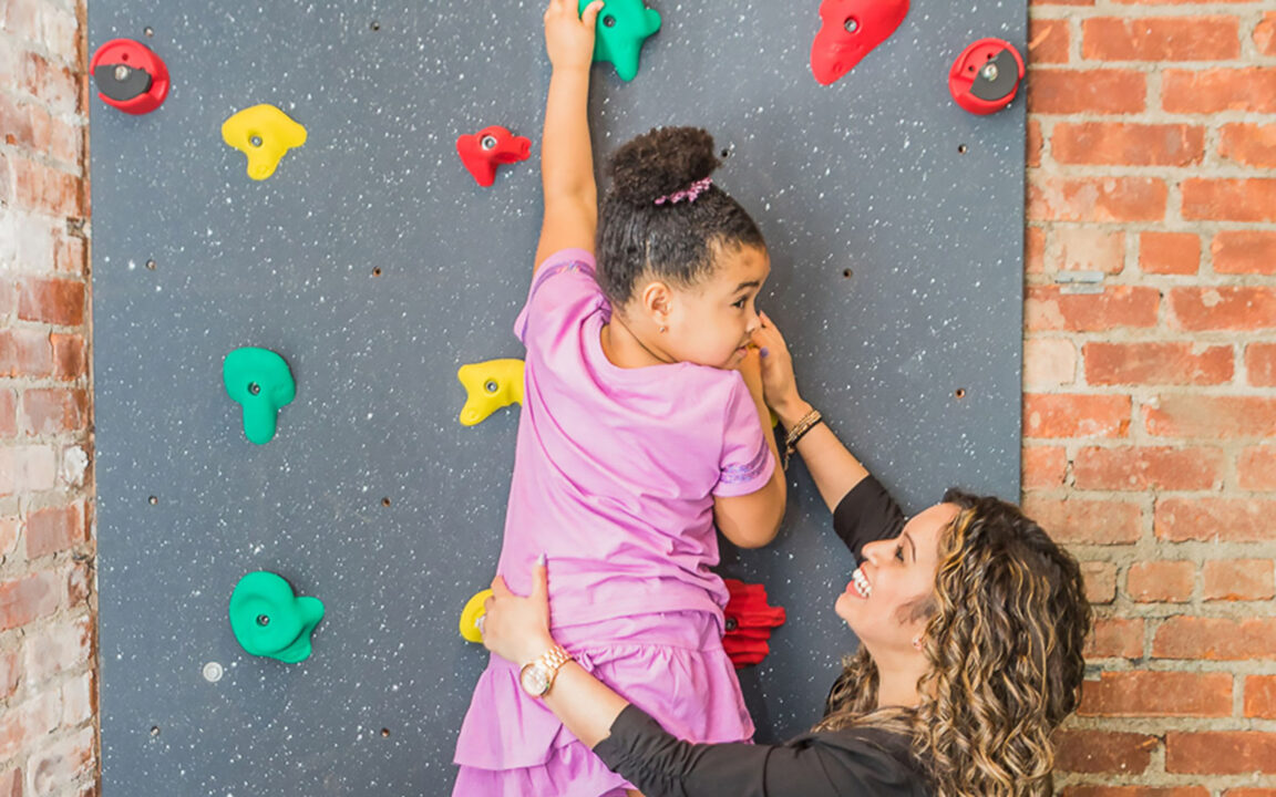 Therapist helping child climb indoors