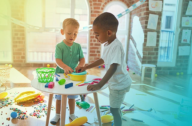 Two young children interacting with therapeutic toys together