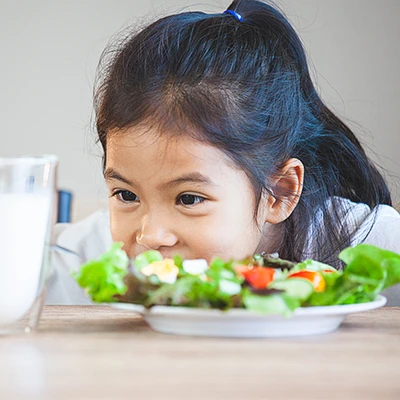 Child looking at milk glass during meal time